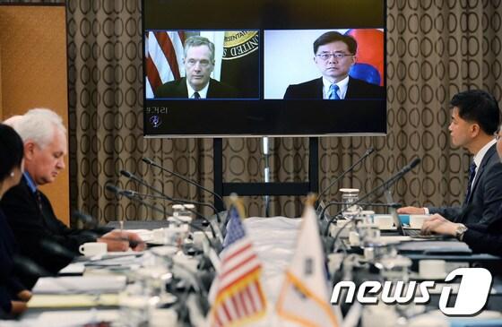 본문 이미지 - 22일 서울 롯데호텔에서 열린 한미 FTA 공동위원회 특별회기에서 양국 수석대표인 김현종 산업통상자원부 통상교섭본부장과 로버트 라이트하이저 미 무역대표부 대표가 영상회의를 갖는 모습을 양국 대표단이 지켜보고 있다. (산업통상자원부 제공) 2017.8.22/뉴스1