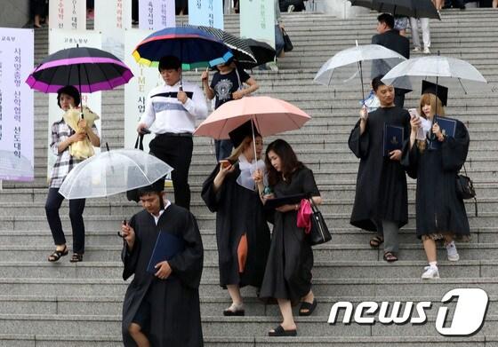 본문 이미지 - 중부지방을 중심으로 많은 비가 내리고 있는 23일 오전 서울 종로구 상명대학교에서 열린 후기학위수여식에 참석한 졸업생들이 우산을 쓰고 졸업식장을 나서고 있다. 2017.8.23/뉴스1 ⓒ News1 박세연 기자