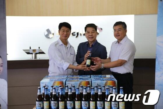 본문 이미지 - 하이트진로 전주공장이 병맥주에 '소방차길터주기운동' 보조상표를 부착해 생산한 후 기념촬영을 하고 있다.(하이트진로제공)2017.8.24/뉴스1ⓒ News1