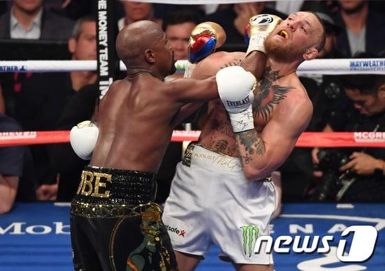 본문 이미지 - 플로이드 메이웨더 주니어(왼쪽)가 코너 맥그리거와의 '세기의 대결'에서 완승을 거뒀다. ⓒ AFP=News1