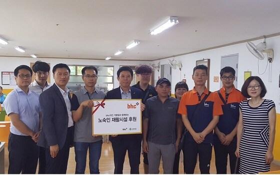 본문 이미지 - 김종옥 bhc치킨 본부장(왼쪽에서 네 번째)과 가맹점 사업주들이 노숙인 재활시설을 방문해 치킨을 전달하고 있다. ⓒ News1