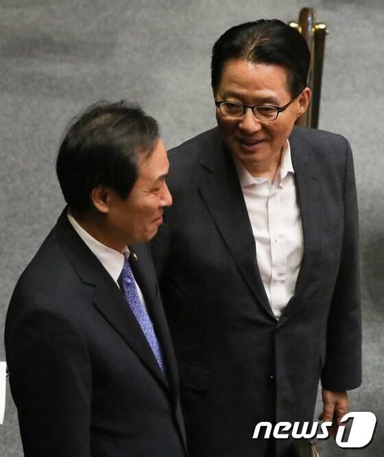 본문 이미지 - 2017년 9월 1일 당시 우상호 더불어민주당 의원과 박지원 국민의당 의원이 서울 여의도 국회 본회의장에서 열린 정기국회 개회식에서 대화를 나누고 있는 모습. ⓒ News1 DB