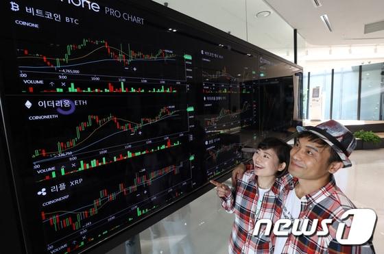 본문 이미지 - 지난 12일 서울 여의도 에스트레뉴 빌딩에 세계 최초로 문을 연 가상화폐 오프라인 거래소 ‘코인원블록스’에서 고객들이 대형 전광판으로 비트코인 등 가상화폐 시세를 확인하고 있다.  2017.9.12/뉴스1 ⓒ News1 허경 기자