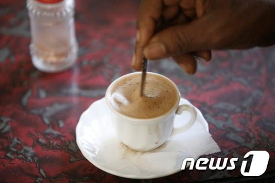 본문 이미지 - 한 손님이 커피를 젓고 있다. 2007.03.12 ⓒ AFP=뉴스1  ⓒ News1 정지윤 기자