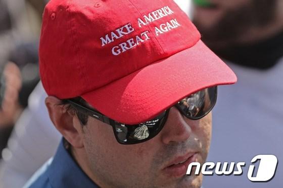 본문 이미지 - 지난해 도널드 트럼프 공화당 대선 캠프의 구호였던 '미국을 다시 위대하게'(Make America Great Again)가 적힌 모자를 쓴 시민. ⓒ AFP=뉴스1