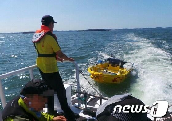 본문 이미지 - 해경이 17일 오후 12시50분께 충남 홍성 죽도 인근 해상에서 전복된 레저보트를 인양하고 있다. (보령해양경찰서 제공) ⓒ News1