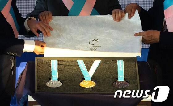 본문 이미지 - 평창올림픽조직위원회가 21일 서울 동대문구 동대문디자인플라자에서 2018 평창 동계올림픽대회 메달을 공개하고 있다. 평창 동계올림픽 메달리스트들에게 수여될 메달은 우리 민족의 상징인 한글을 모티브로 세계 각국 선수의 열정과 노력을 담아 제작됐다.  2017.9.21/뉴스1 ⓒ News1 오대일 기자