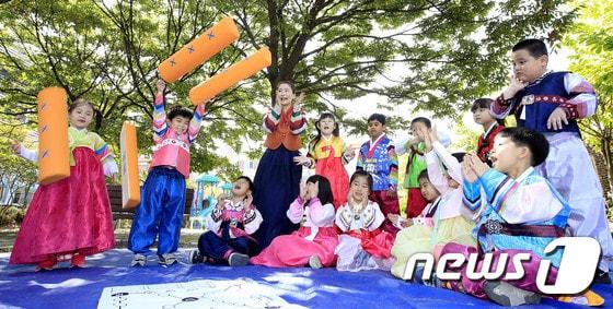 본문 이미지 - 어린이들이 한복을 입고 전통놀이인 윷놀이를 하고 있는 모습  ⓒ News1 