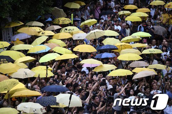 본문 이미지 - 28일 홍콩 시민들이 '우산혁명' 3주년을 기념해 길거리로 나섰다. 사진은 혁명의 상징인 우산을 펼쳐 들어올리는 시민들의 모습. ⓒ AFP=뉴스1