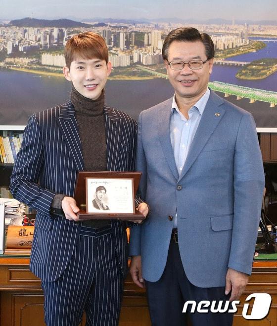 본문 이미지 - 29일 서울 용산구청에서 성장현 구청장이 가수 조권에게 홍보대사 위촉장을 전달하고 있다. 조권은 용산구 관련 행사나 홍보물 제작에 참여하는 등 다양한 방식으로 구를 알리는 역할을 하게 된다. (용산구청 제공) 2017.9.29/뉴스1