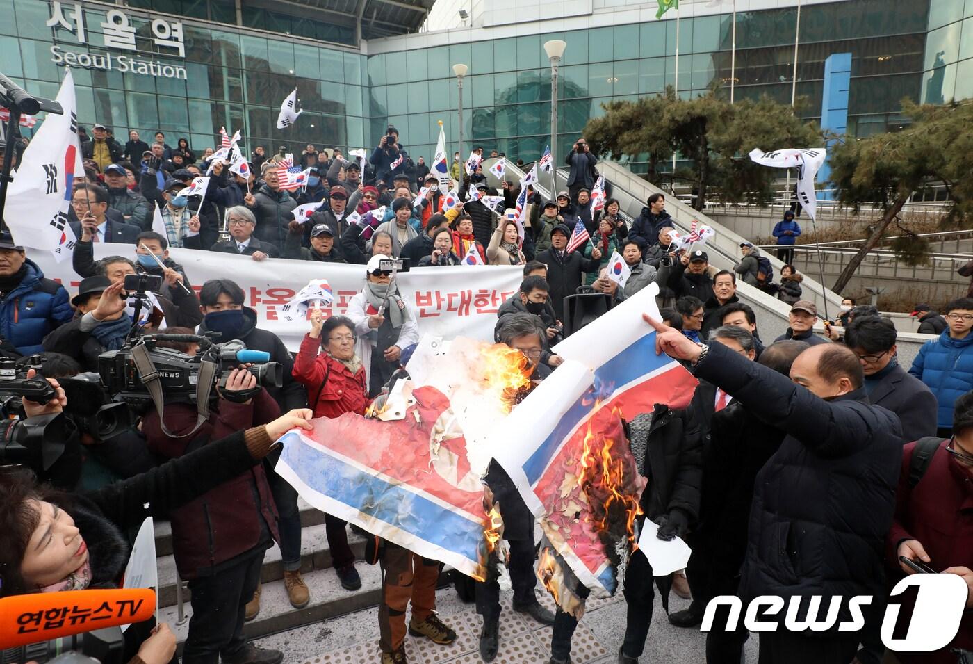 본문 이미지 - 조원진 당시 대한애국당 대표와 보수단체 회원들이 2018년 1월22일 오전 서울역 광장에서 긴급기자회견을 열고 평창동계올림픽 남북 단일팀 합의에 반대하며 인공기를 불에 태우고 있는 모습(자료사진). 2018.1.22/뉴스1 ⓒ News1 구윤성 기자
