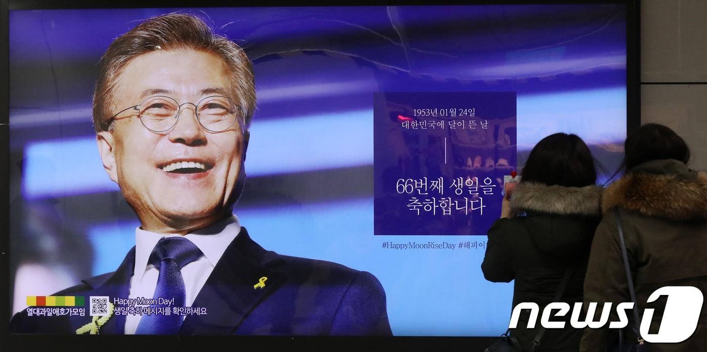 본문 이미지 - 문재인 대통령의 생일인 24일 오후 서울 종로구 5호선 광화문역에서 시민들이 문 대통령 생일 광고를 살펴보고 있다. 2018.1.24/뉴스1 ⓒ News1 민경석 기자