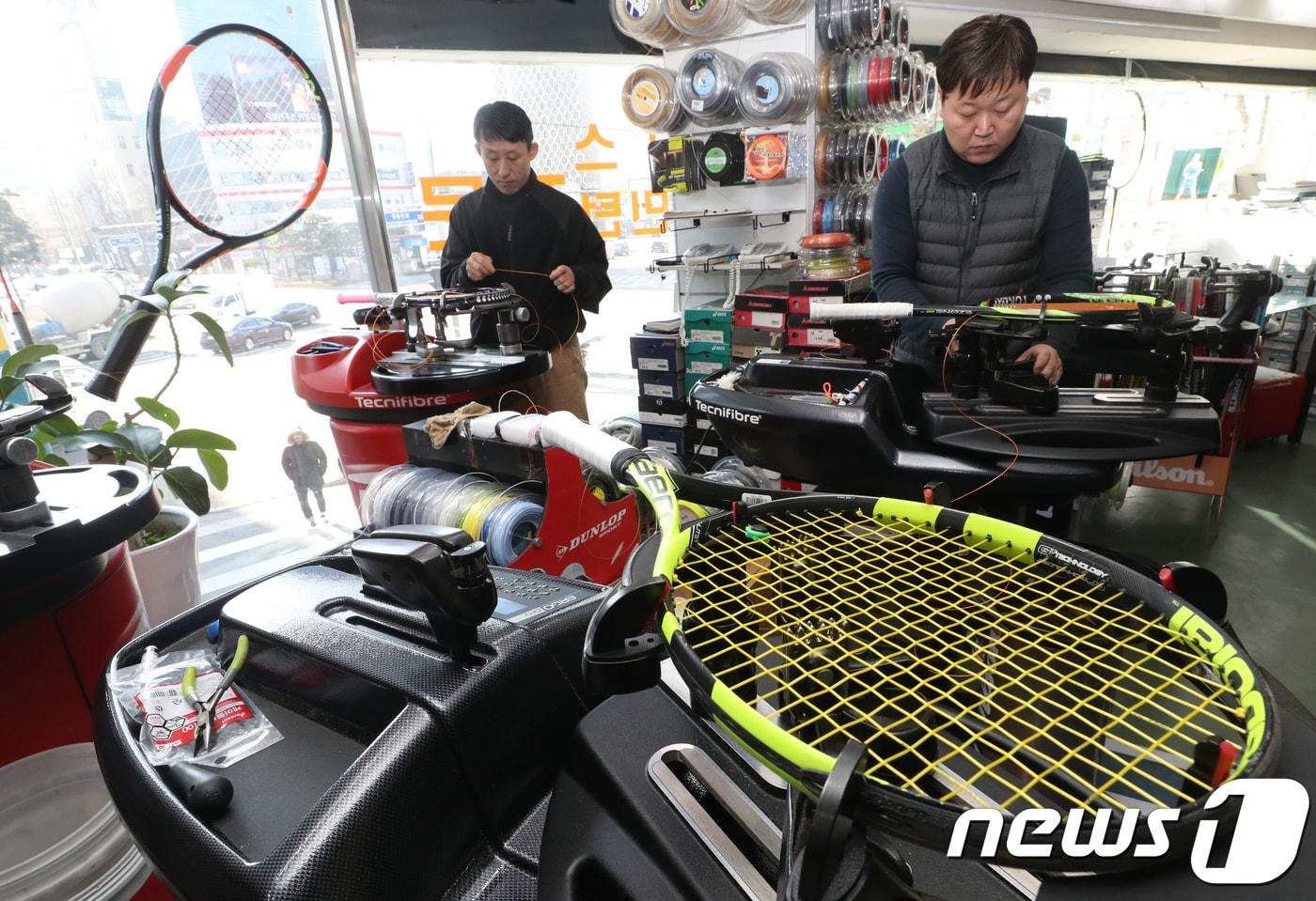 본문 이미지 - 서울 중구 테니스스퀘어에서 직원들이 밀려드는 주문에 테니스 라켓에 줄을 끼우는 작업을 하고 있다. (기사내용과 무관) 2018.1.26/뉴스1 ⓒ News1 송원영 기자