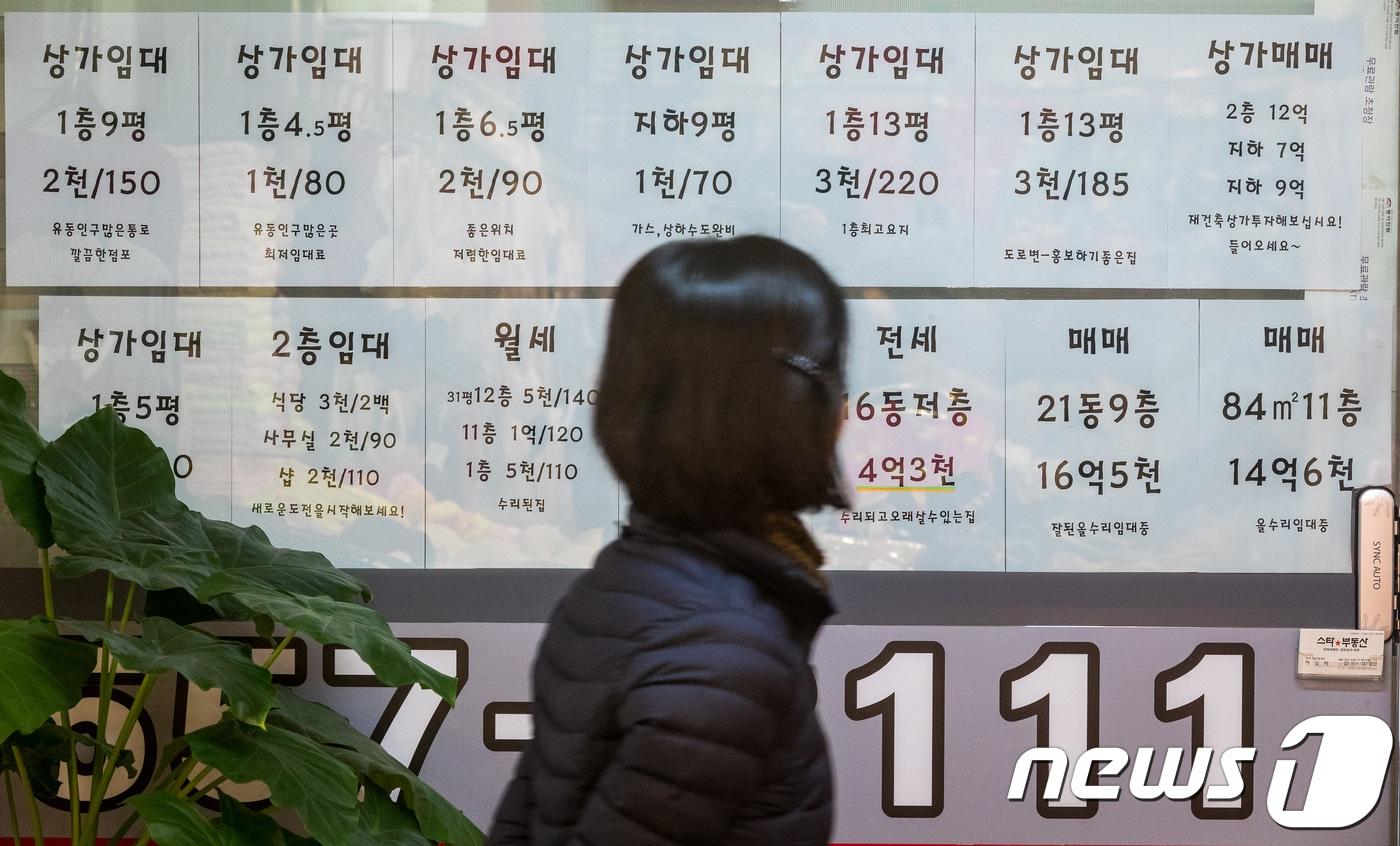 본문 이미지 - 서울 강남구의 한 공인중개소 앞에 묻은 매물 목록을 유심히 살피는 주민의 모습. ⓒ News1