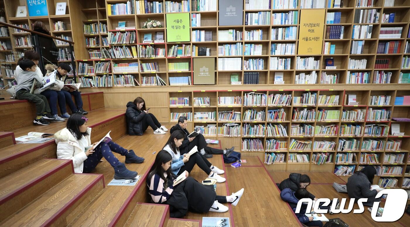 본문 이미지 - 겨울방학을 맞은 어린이들과 학부모가 4일 오후 서울도서관에서 독서삼매경에 빠져 있다. 2018.1.4/뉴스1 ⓒ News1