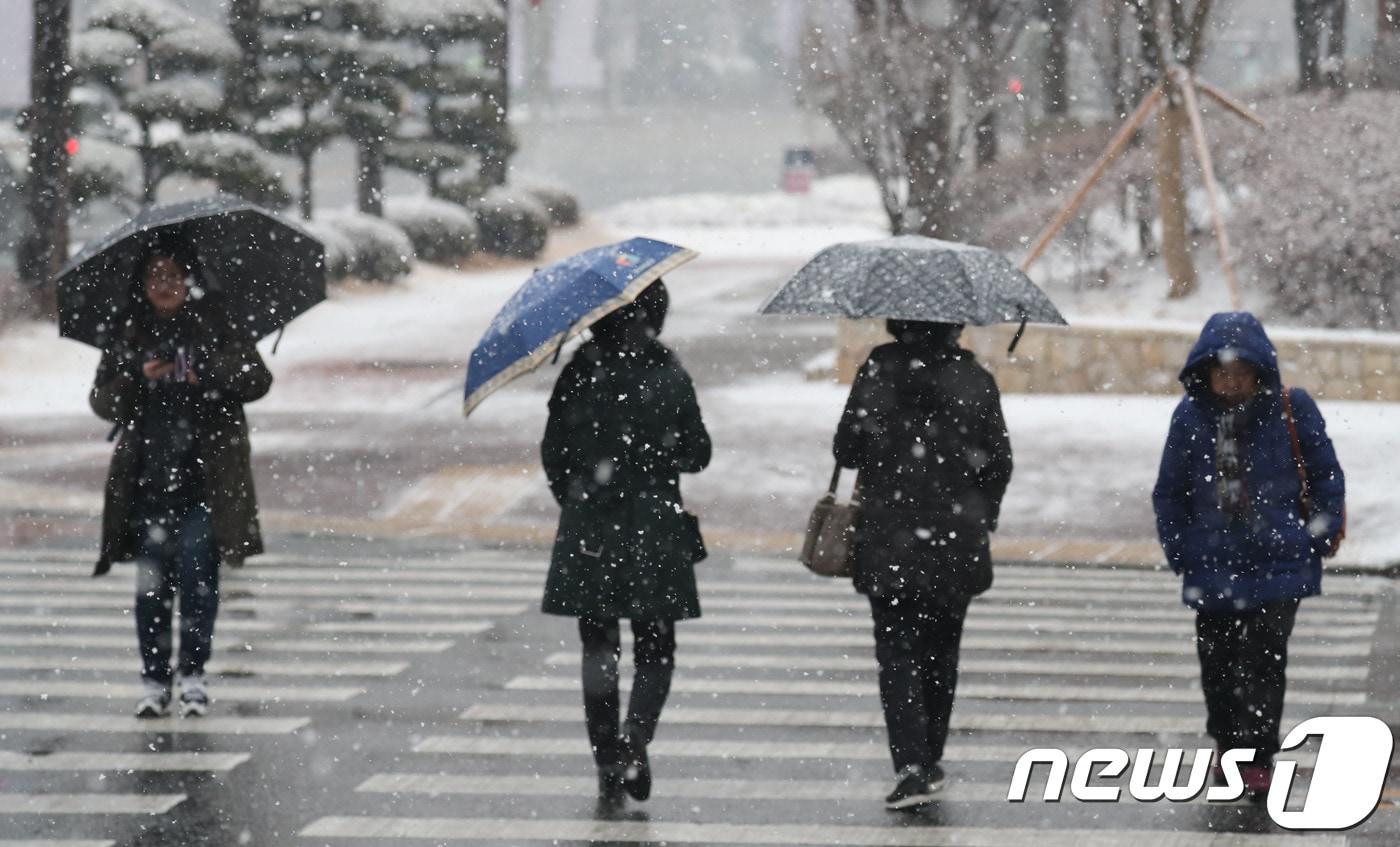 28일 대전·충남은 흐린 가운데 오후까지 가끔 비 또는 눈이 내릴 것으로 예보됐다. 대전 서구 한 거리에서 시민들이 우산을 쓴 채 신호등을 걷고 있다. /뉴스1 ⓒ News1