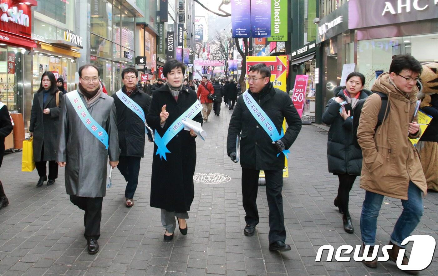 김영주 고용노동부 장관이 지난 9일 오후 서울 중구 명동 한 상점에서 최저임금 준수 필요성을 설명하고, 일자리 안정자금 홍보 캠페인을 하고 있다.  (고용노동부 제공) 2018.1.9/뉴스1