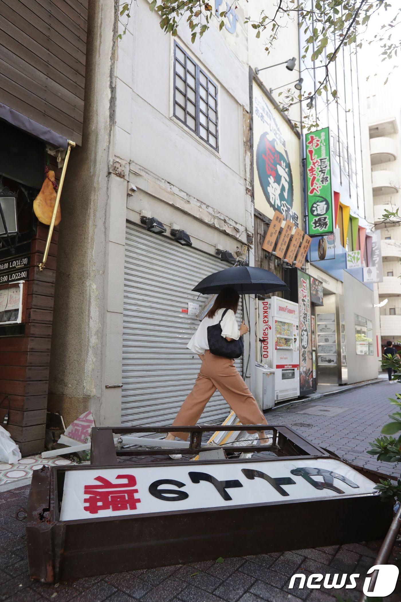 본문 이미지 - 태풍 '짜미'의 강풍으로 상점 간판이 떨어져 있다. ⓒ AFP=뉴스1
