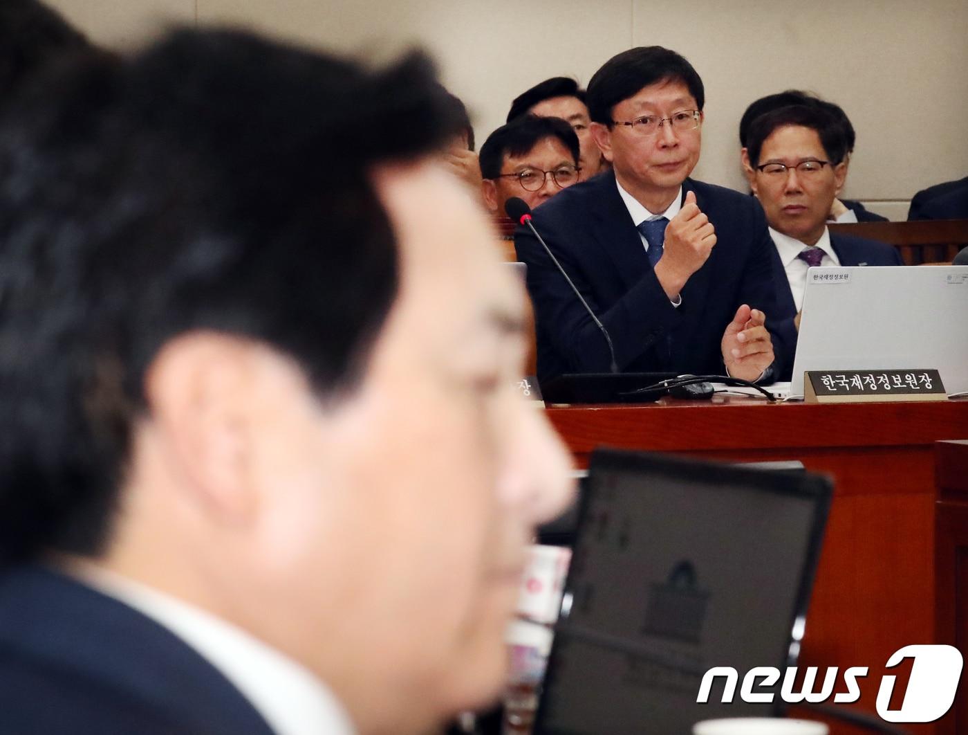 본문 이미지 - 김재훈 한국재정정보연구원장이 16일 서울 여의도 국회에서 열린 기회재정위원회의 국정감사에서 의원들의 의사진행 발언을 듣고 있다. 이날 감사는 심재철의원의 한국재정정보원의 국회 국정감사에 제척 대상인지를 놓고 여야 간 공방을 벌이다 감사가 중지, 재개됐다.2018.10.16/뉴스1 ⓒ News1 김명섭 기자