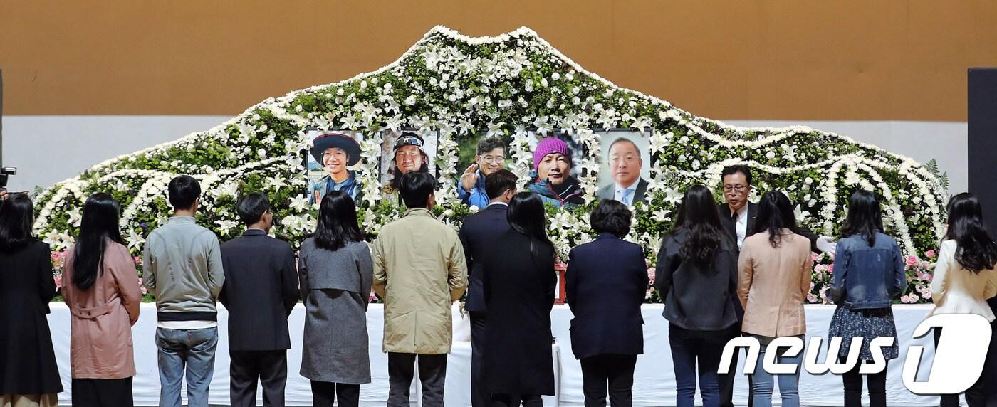 본문 이미지 - 네팔 히말라야 등반 도중 불의의 사고로 사망한 '김창호 대장과 유영직·이재훈·임일진 대원, 정준모 한국산악회 이사'의 합동분향소가 17일 오전 서울 동대문구 서울시립대학교 대강당에 마련됐다. 합동분향소를 찾은 교직원들이 헌화를 하고 있다. 2018.10.17/뉴스1 ⓒ News1 이재명 기자
