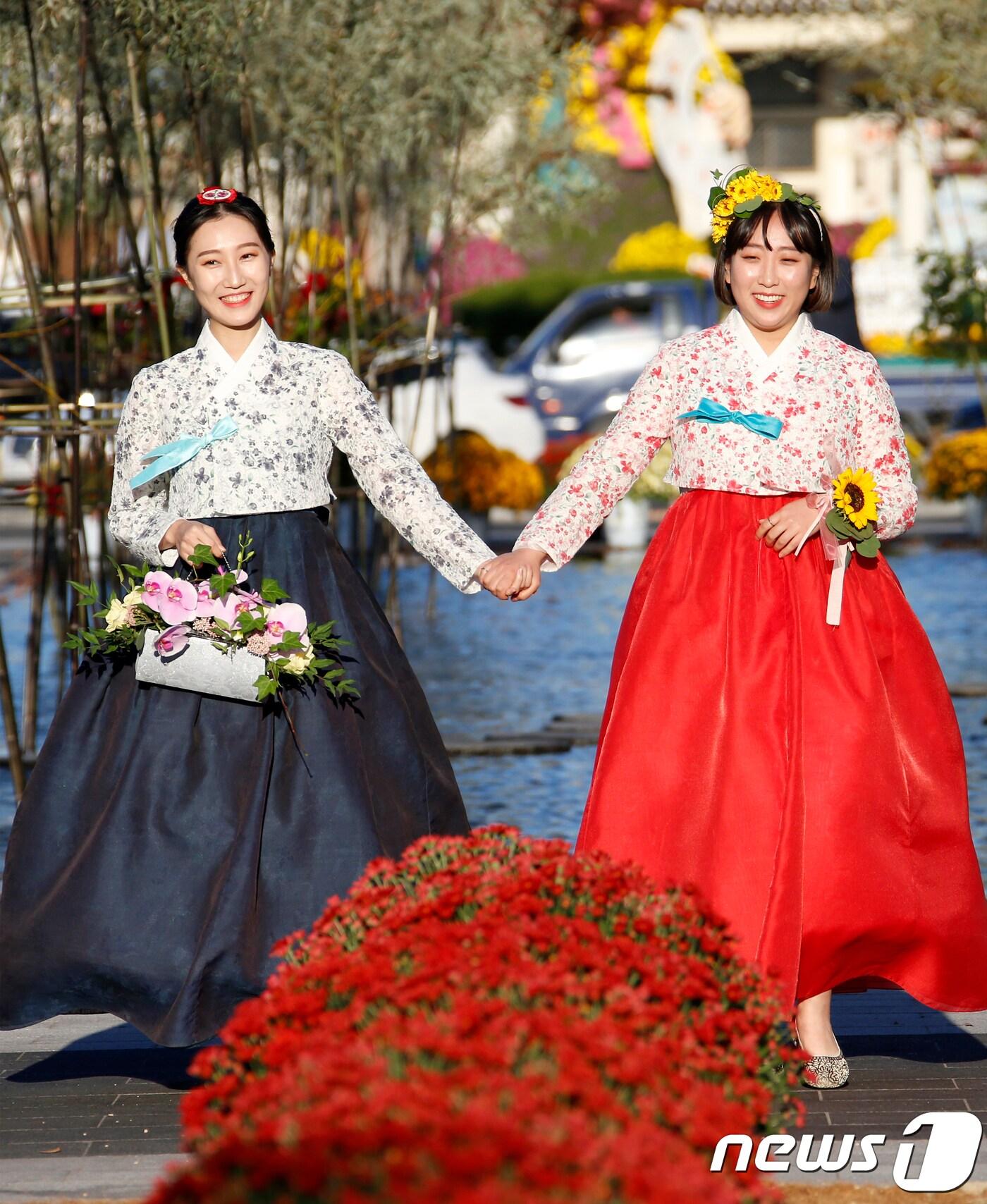 본문 이미지 - 19일 오후 전북 전주시 전주역앞 첫마중길 일원에서 제2회 첫마중길 꽃마중 예술제가 열린 가운데 오프닝행사로 한복 부케쇼가 펼쳐지고 있다. 가을꽃과 화훼인이 디자인한 가드닝 작품들이 어우러지는 첫 마중길 꽃마중 예술제는 3일 동안 열린다.(전주시 제공)2018.10.19/뉴스1 ⓒ News1 김춘상 기자