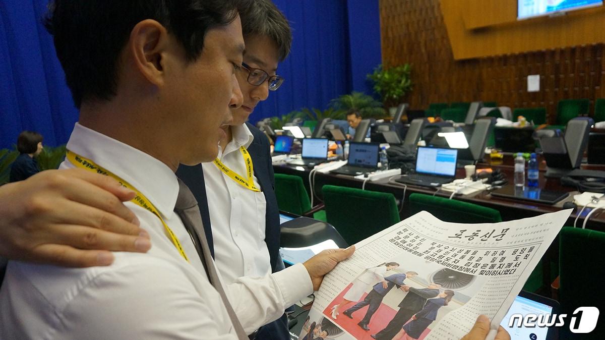 본문 이미지 - 2018년 9월 평양 남북정상회담 당시 평양 프레스센터에서 북한 로동신문을 보고 있는 한국 취재진. 이는 청와대가 그해 10월 2일 공개한  비공식 사진인 'B' 컷. (청와대 제공) 2018.10.2/뉴스1