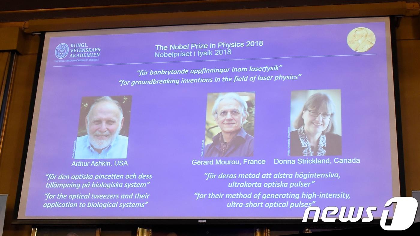 2018년 노벨 물리학상 수상자 명단이 2일(현지시간) 스웨덴 스톡홀름에서 발표되고 있다. 사진 왼쪽부터 미국의 아서 애쉬킨, 프랑스의 제라르 무루, 캐나다의 도나 스트릭랜드. ⓒ AFP=뉴스1