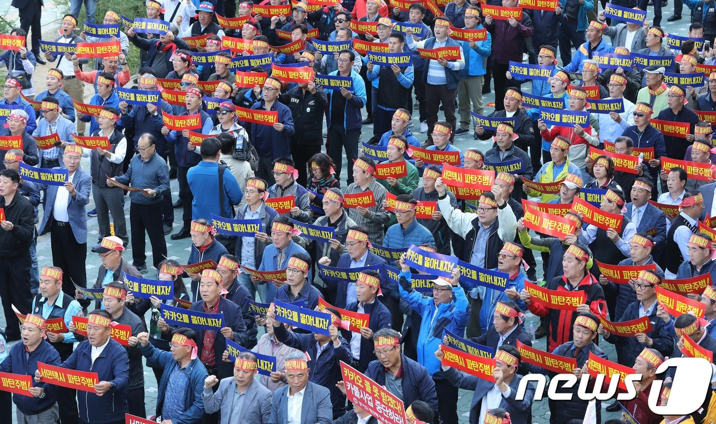 4일 오전 경기도 성남시 분당구 판교역 앞에서 열린 카카오 모빌리티 규탄 집회에서 수도권 전국택시노조, 전국민주택시노조, 전국택시운송사업조합 조합원들이 카카오 모빌리티의 승차 공유(카풀) 서비스 도입 추진을 반대하는 구호를 외치고 있다. 2018.10.4/뉴스1 ⓒ News1 오장환 기자