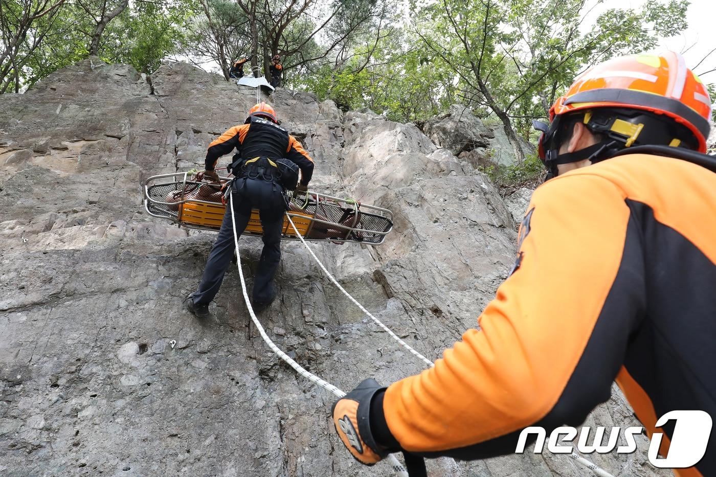 본문 이미지 - 대구 북구 연경동 암벽훈련장에서 실시된 ‘산악사고 대비 종합구조훈련’에 참가한 119구조대원이 인명구조훈련에 임하고 있다. 2018.10.4/뉴스1 ⓒ News1 공정식 기자