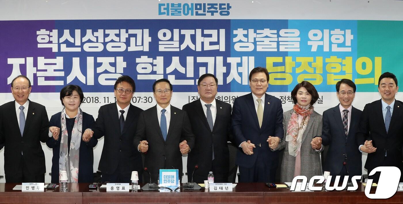 본문 이미지 - 김태년 더불어민주당 정책위의장과 최종구 금융위원장 등 참석자들이 지난달 1일 서울 여의도 국회의원회관에서 열린 '혁신성장과 일자리 창출을 위한 자본시장 혁신과제 당정협의'에서 손을 맞잡고 있다. 2018.11.1/뉴스1 ⓒ News1 민경석 기자