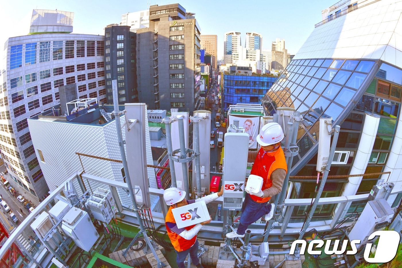 SK 텔레콤 직원들이 5G 전파 송출을 보름여 앞둔 14일 오전 서울 중구 명동의 한 빌딩 옥상에서 5G 기지국을 설치하고 있다. 직원의 손에 닿은 장비 외에는 모두 4G LTE 장비로 5G 장비는 여러대의 4G LTE 장비를 하나로 대체할 수 있다. 2018.11.14/뉴스1 ⓒ News1 안은나 기자