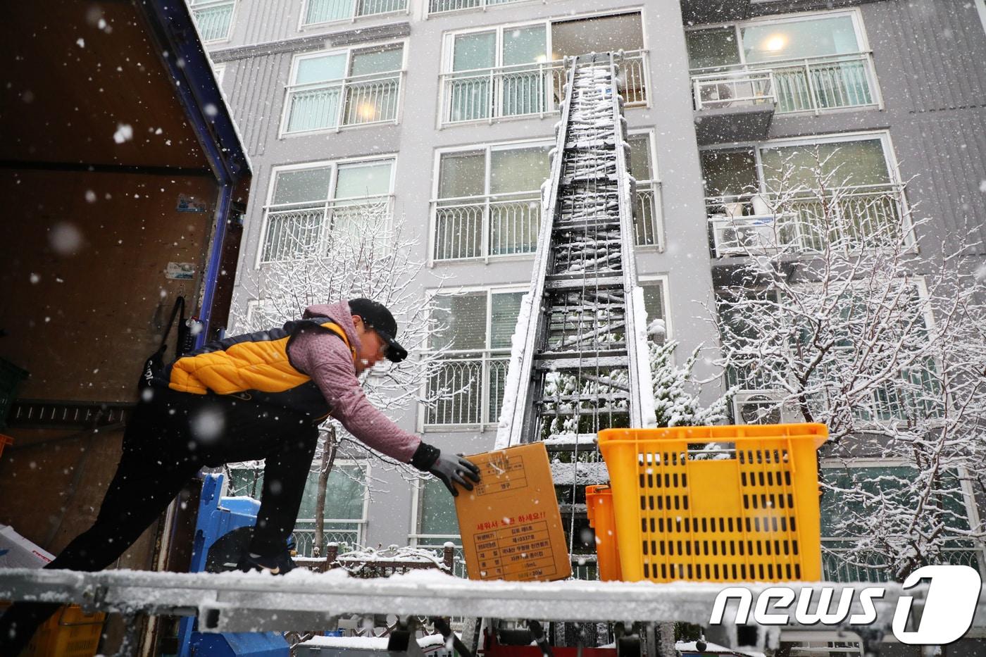눈을 맞으며 이삿짐을 옮기는 이삿짐센터 관계자. (뉴스1DB) ⓒ News1 이찬우 기자