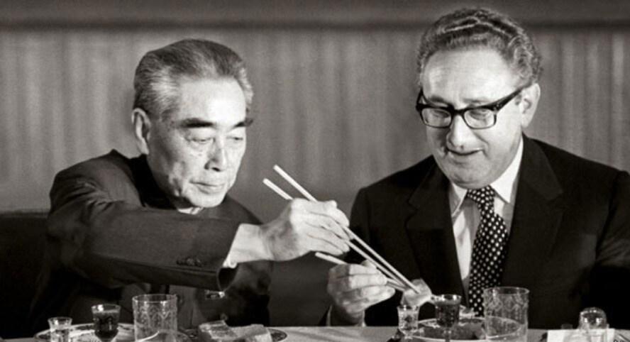 본문 이미지 - 저우언라이 외교부장이 키신저 국무장관에게 젓가락질을 가르쳐 주고 있다. 미중  데탕트 시대를 상징하는 '세기의 한 컷'이다. - 바이두 갈무리