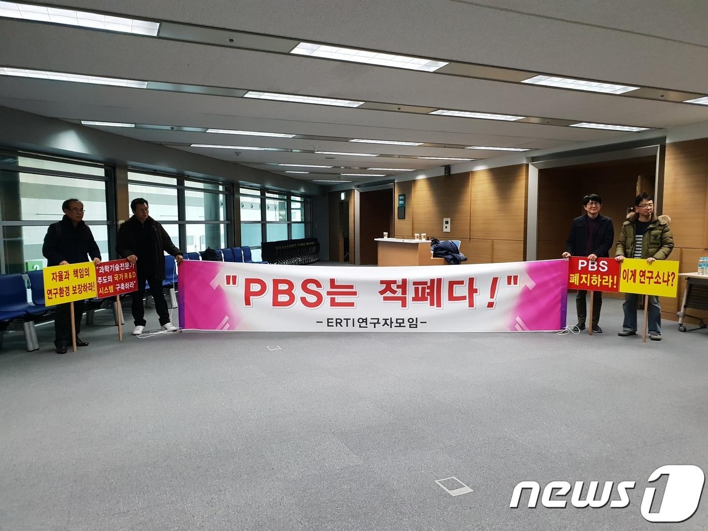 본문 이미지 - 지난 12일 서울시 양재동 aT센터에서 열린 '출연연 PBS제도 발전방안' 전문가 토론회에서 'PBS는 적폐다'라는 피켓을 들고 일부 연구자들이 PBS 제도 개편 방안에 대해 항의를 하고 있다. ⓒ News1