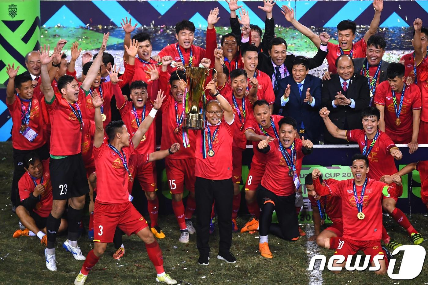 박항서 감독(가운데)이 15일(한국시간) 베트남 하노이의 미딩 국립경기장에서 2018 아세안축구연맹(AFF) 스즈키컵 우승 트로피를 들어 올리고 있다. ⓒ AFP=News1