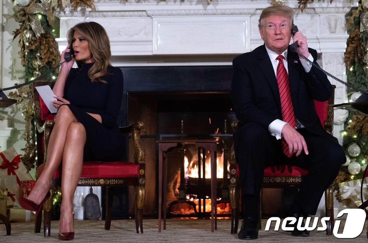 본문 이미지 - 백악관으로 연결된 NORAD 산타 추적 프로젝트로 걸려온 전화에 대답하고 있는 도널드 트럼프 미국 대통령과 부인 멜라니아 트럼프. ⓒ AFP=뉴스1