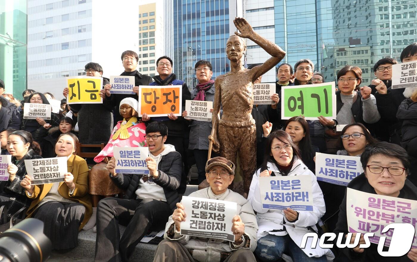 본문 이미지 - 부산 동구 일본총영사관 앞 평화의소녀상 옆에서 적폐청산사회대개혁 부산본부 강제징용노동자상 건립특별위원회, 부산여성행동 등 시민단체회원들이 지난해12월 강제징용노동자상 모형을 평화의 소녀상 옆으로 옮기는 퍼포먼스를 하는 모습. ⓒ News1 