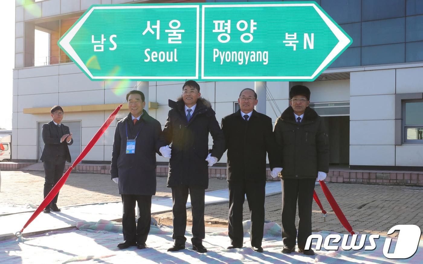 본문 이미지 - 26일 오전 북한 개성시 판문역에서 열린 남북 동서해선 철도, 도로 연결 및 현대화 착공식에 참석한 이강래(왼쪽부터) 한국도로공사 사장, 천해성 통일부 차관, 북한 박호영 국토환경보호성 부상 등이 서울-평양 표지판 제막식을 하고 있다. 2018.12.26/뉴스1 ⓒ News1 사진공동취재단