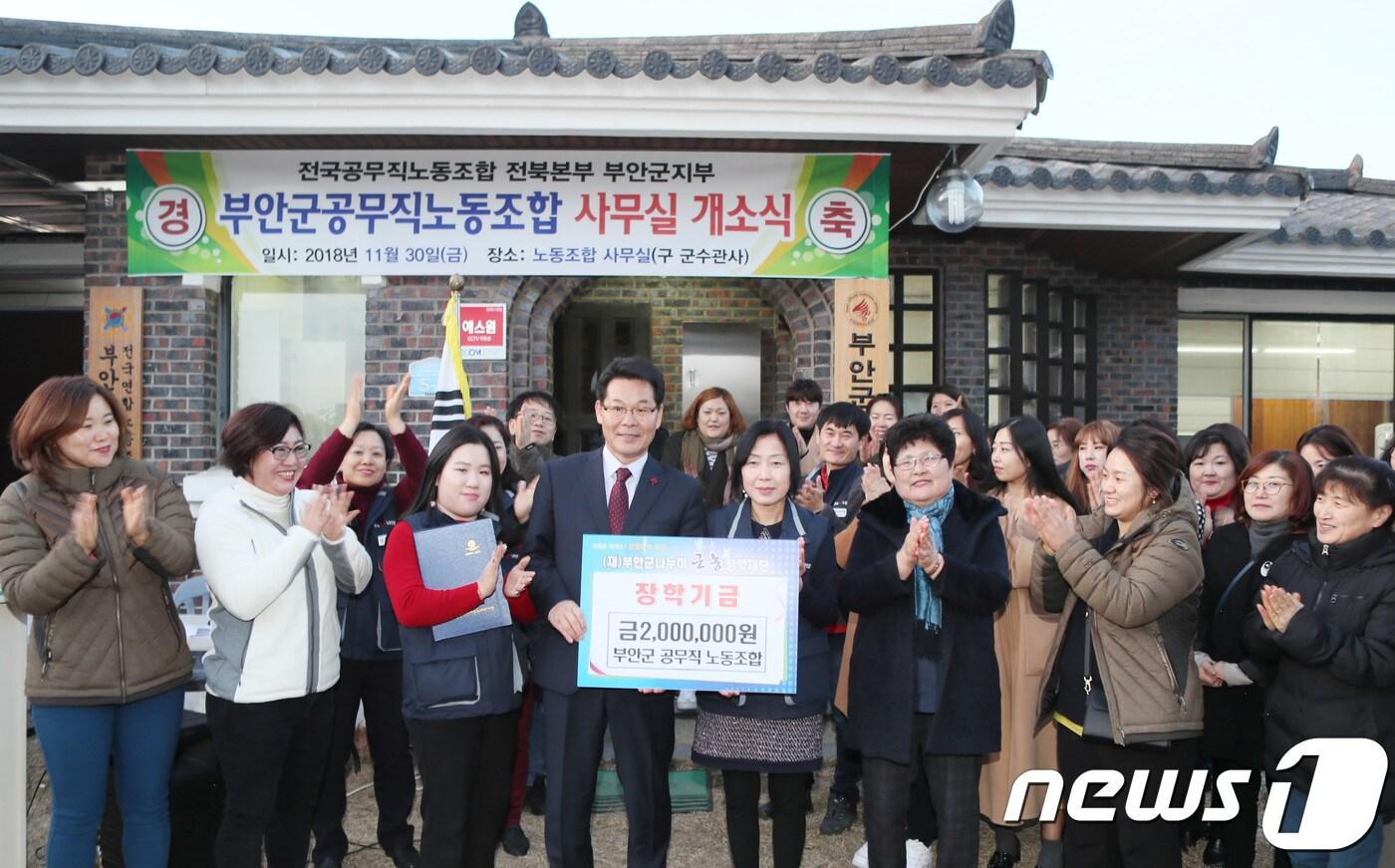 본문 이미지 - 전북 부안군공무직노동조합 조합원들이 3일 오후 노동조합사무실 개소식을 마친 뒤 마련한 장학금을 권익현 부안군수에게 전달하고 있다.(노동조합 제공) /뉴스1