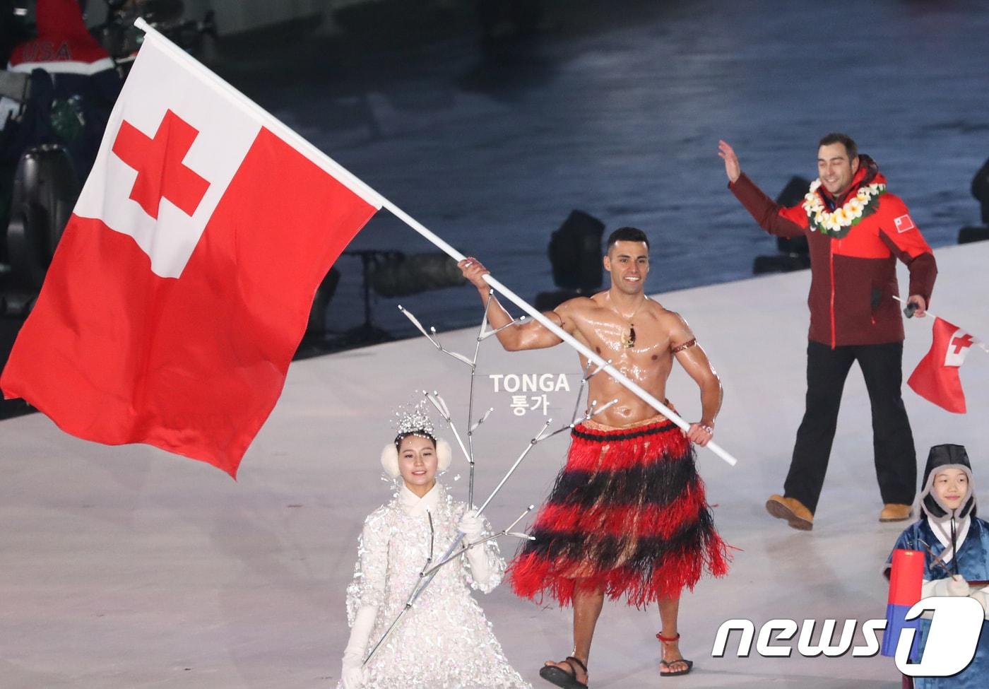 본문 이미지 - 지난 2018년 강원도 평창올림픽스타디움에서 열린 평창동계올림픽 개막식에서 퉁가 선수단의 기수 피타니콜라스 타우파토푸아가 국기를 흔들며 입장하고 있다. 2018.2.9/뉴스1 ⓒ News1 허경 기자
