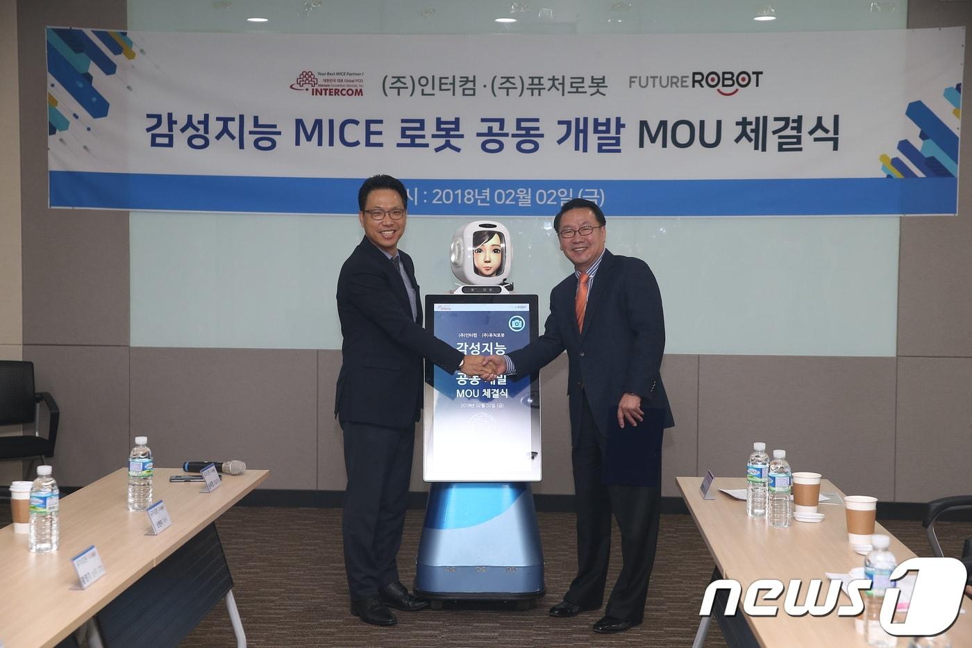 본문 이미지 - 최태영 인터컴 대표이사(오른쪽)와 송세경 퓨처로봇 대표이사(왼쪽)이 2일 '감성지능 MICE 로봇 공동개발' MOU 체결식에 참석해 손을 맞잡고 있다.   ⓒ News1