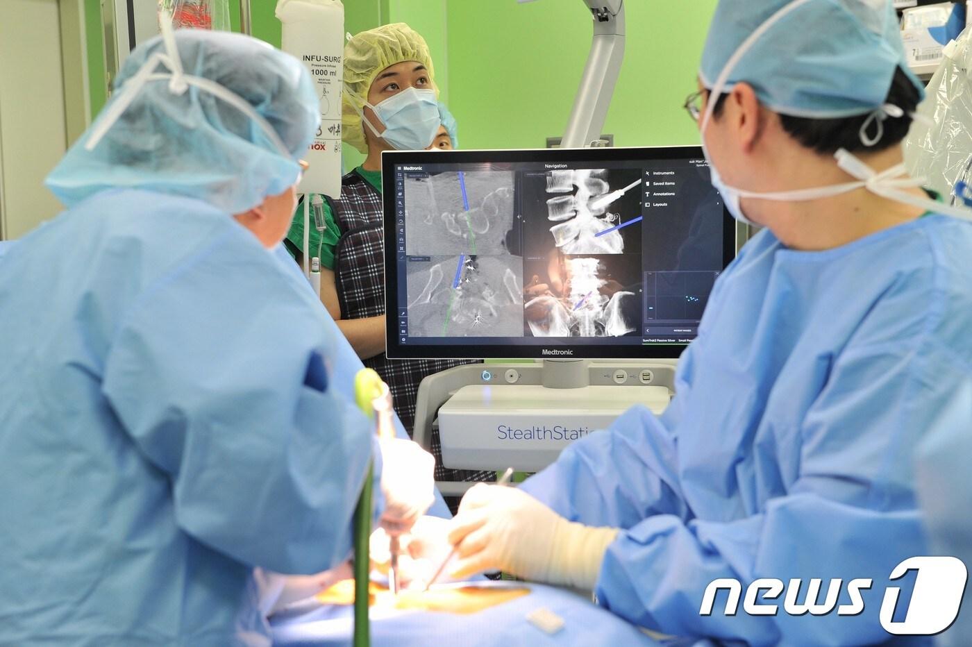 본문 이미지 - 2세대 오암(O-ARM)과 내비게이션을 사용해 척추환자를 수술 중인 세브란스병원 의료진.ⓒ News1