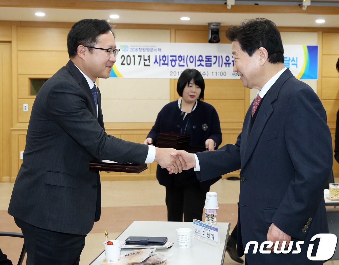 본문 이미지 - BNK경남은행 사회공헌홍보부 이성철 부장(왼쪽)이 21일 창원시청에서 안상수 시장으로부터 2017 사회공헌(이웃돕기) 유공자 감사패를 수여 받고 악수를 하고 있다.(경남은행 제공)2018.2.21./뉴스1ⓒ News1