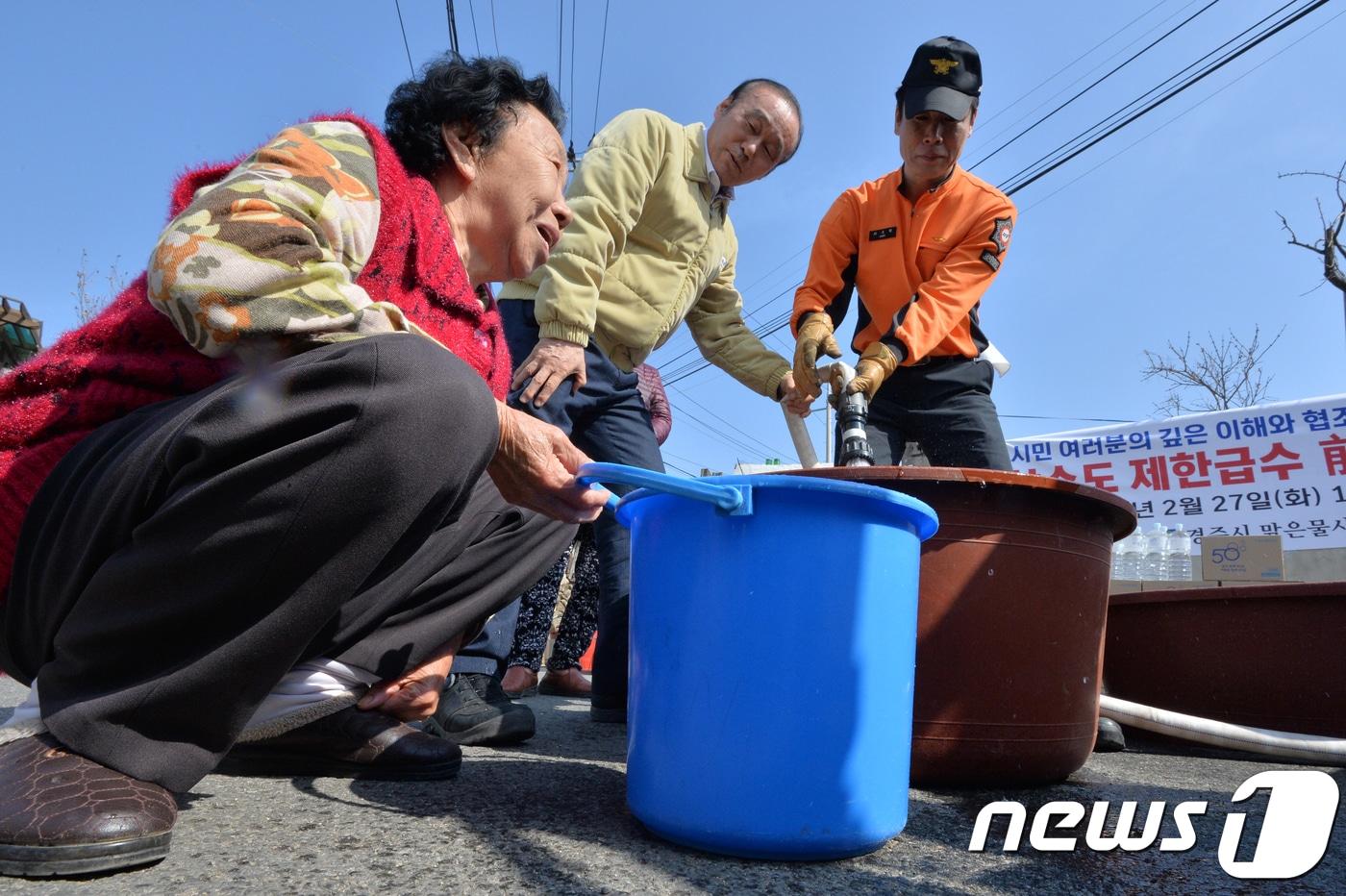 본문 이미지 - 최양식 경북 경주시장이 27일 진현동에서 마을 주민들과 함께 상수도 비상 급수 훈련을 하고 있다.경주시는 3월 한달간 최소 200mm이상의 비가 내리지 않은 경우 제한급수를 실시할 계획을 세워둔 상태다.지난해 경주지역의 누적 강수량은 617mm로 평년(1159mm)의 53.3%, 평균 저수율은 49.8%로 평년(81.8%)의 절반 정도다.2018.2.27/뉴스1 ⓒ News1 최창호 기자