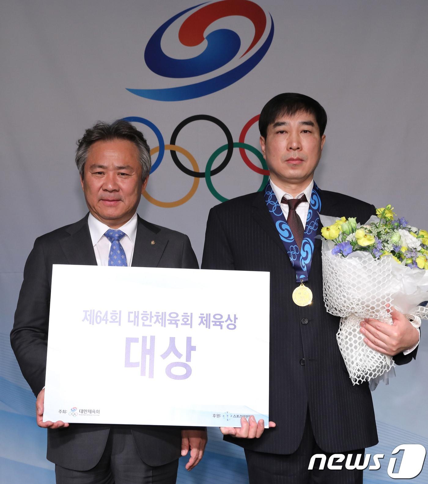 본문 이미지 - 28일 오전 서울 송파구 방이동 올림픽파크텔에서 열린 제64회 대한체육회 체육상 시상식에서 체육대상을 받은 김민석 선수의 아버지 김남수 씨가 대리수상을 하고 있다. 김민석은 2018 평창동계올림픽 스피드스케이팅 남자 팀추월에서 은메달을 1,500m에서 동메달을 차지했다. 왼쪽은 이기흥 대한체육회장. 2018.2.28/뉴스1 ⓒ News1 임세영 기자