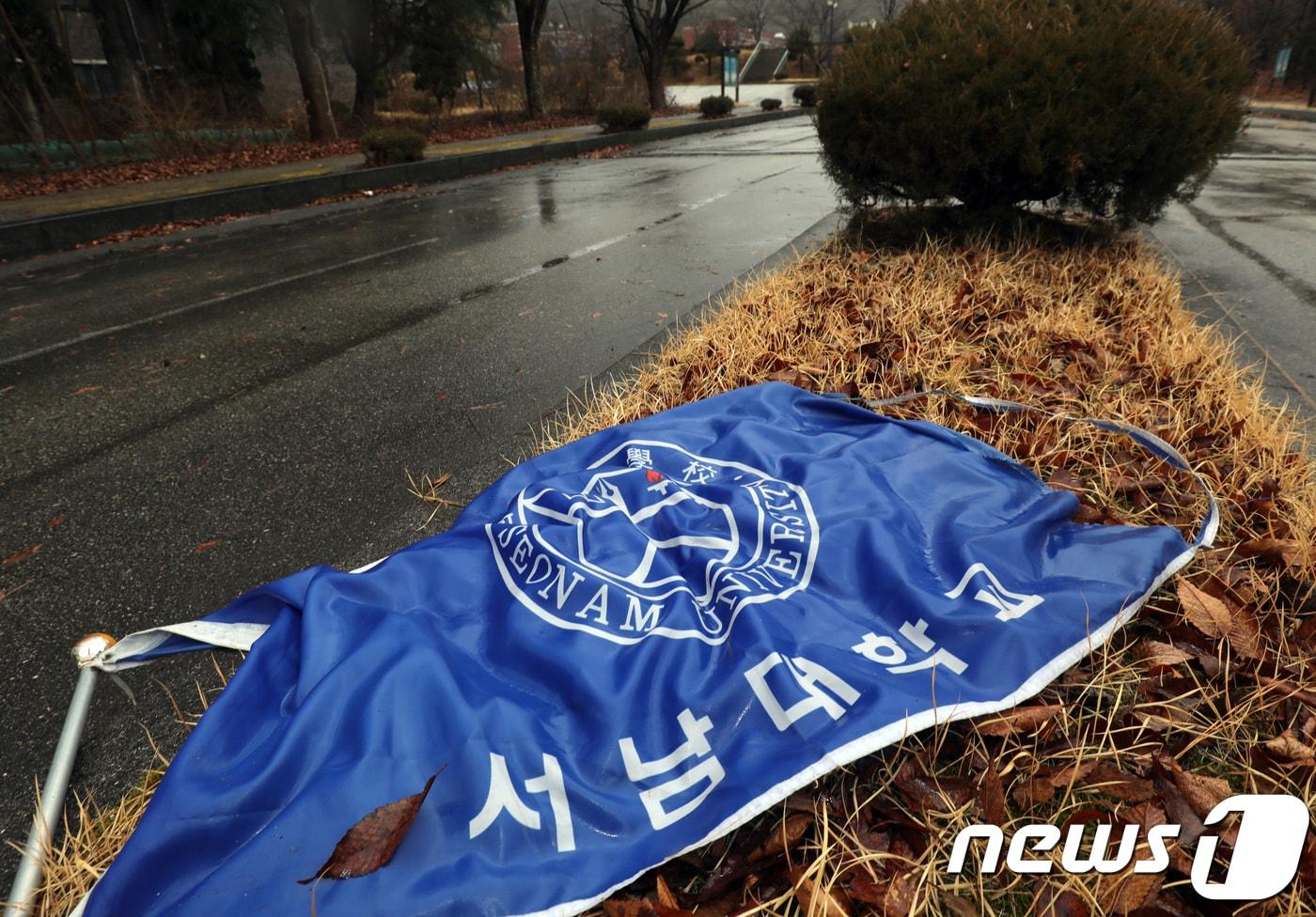 본문 이미지 - 전북 남원시 서남대학교 교정에 학교 깃발이 떨어져 있다. 서남대학교는 전 이사장의 횡령 등 비리로 인한 경영악화로 교육부의 폐교명령을 받았다.2018.2.28 ⓒ 뉴스1