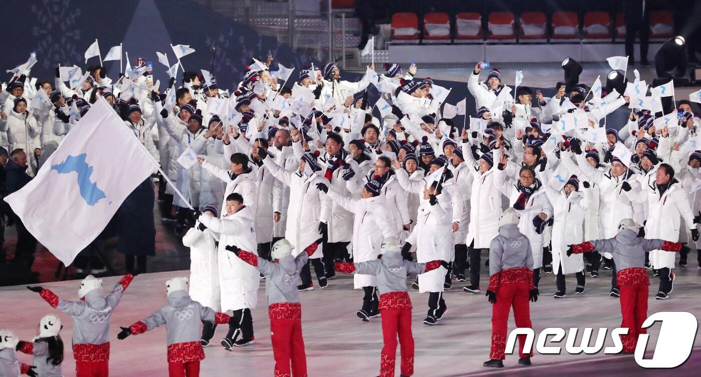 2018 평창동계올림픽이 대단원의 막을 올린 9일 강원도 평창올림픽스타디움에서 열린 평창동계올림픽 개막식에서 남북한 선수단이 한반도기를 흔들며 입장하고 있다. 올림픽에서 남북한 선수단이 공동입장하는 것은 2006년 토리노동계올림픽 이후 13년 만이다. 3만5000여명의 관람객과 전 세계 시청자 25억여명의 시선을 사로잡을 평창동계올림픽 개막식은 '행동하는 평화(Peace in motion)'를 주제로 2시간 동안 진행된다. 2018.2.9/뉴스1 ⓒ News1 허경 기자