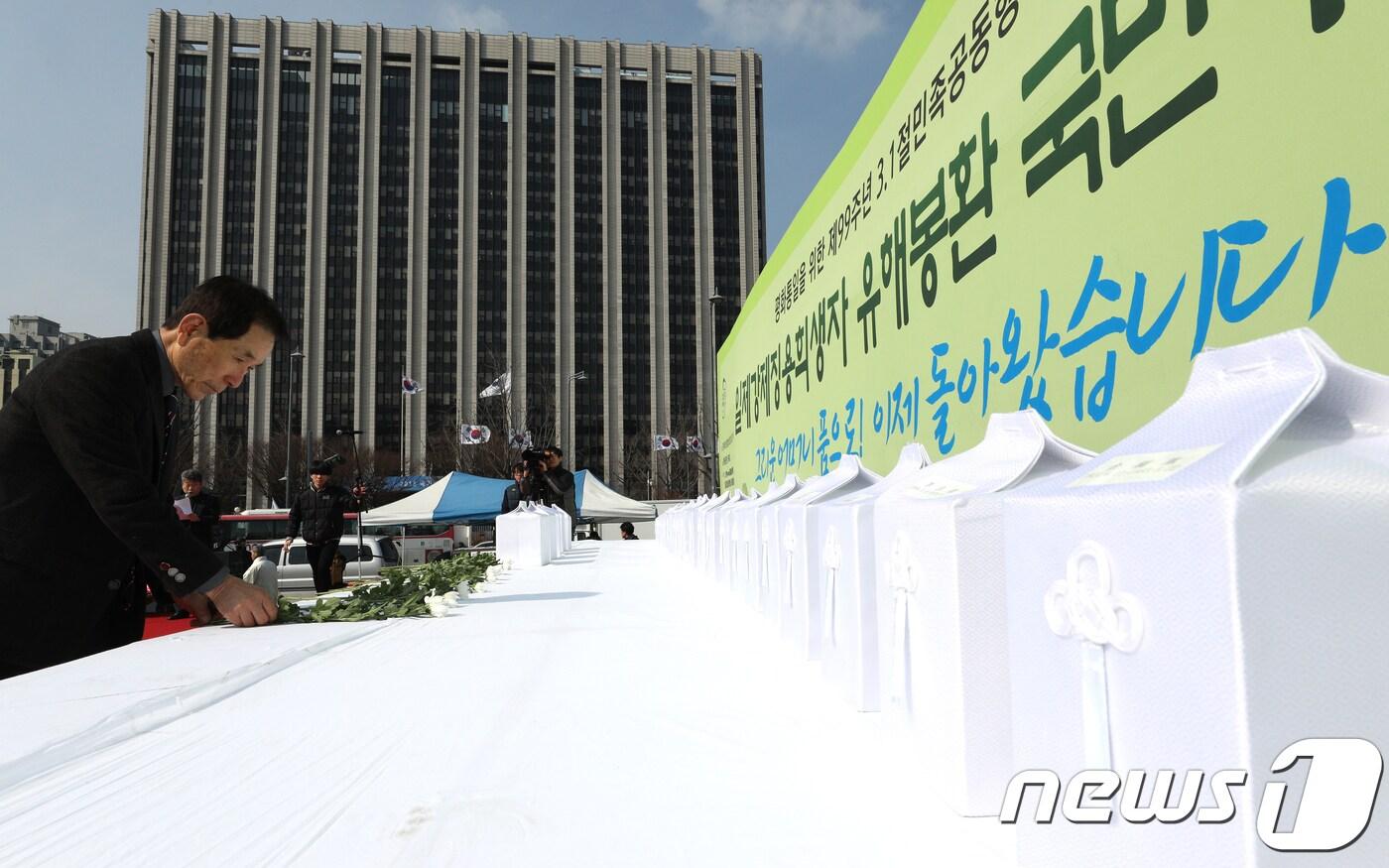 본문 이미지 - 제99주년 3·1절인 1일 오전 서울 광화문광장에서 열린 일제 강제징용 희생자 유해봉환 국민추모제에서 참가자들이 헌화를 하고 있다. 2018.3.1/뉴스1 ⓒ News1 신웅수 기자