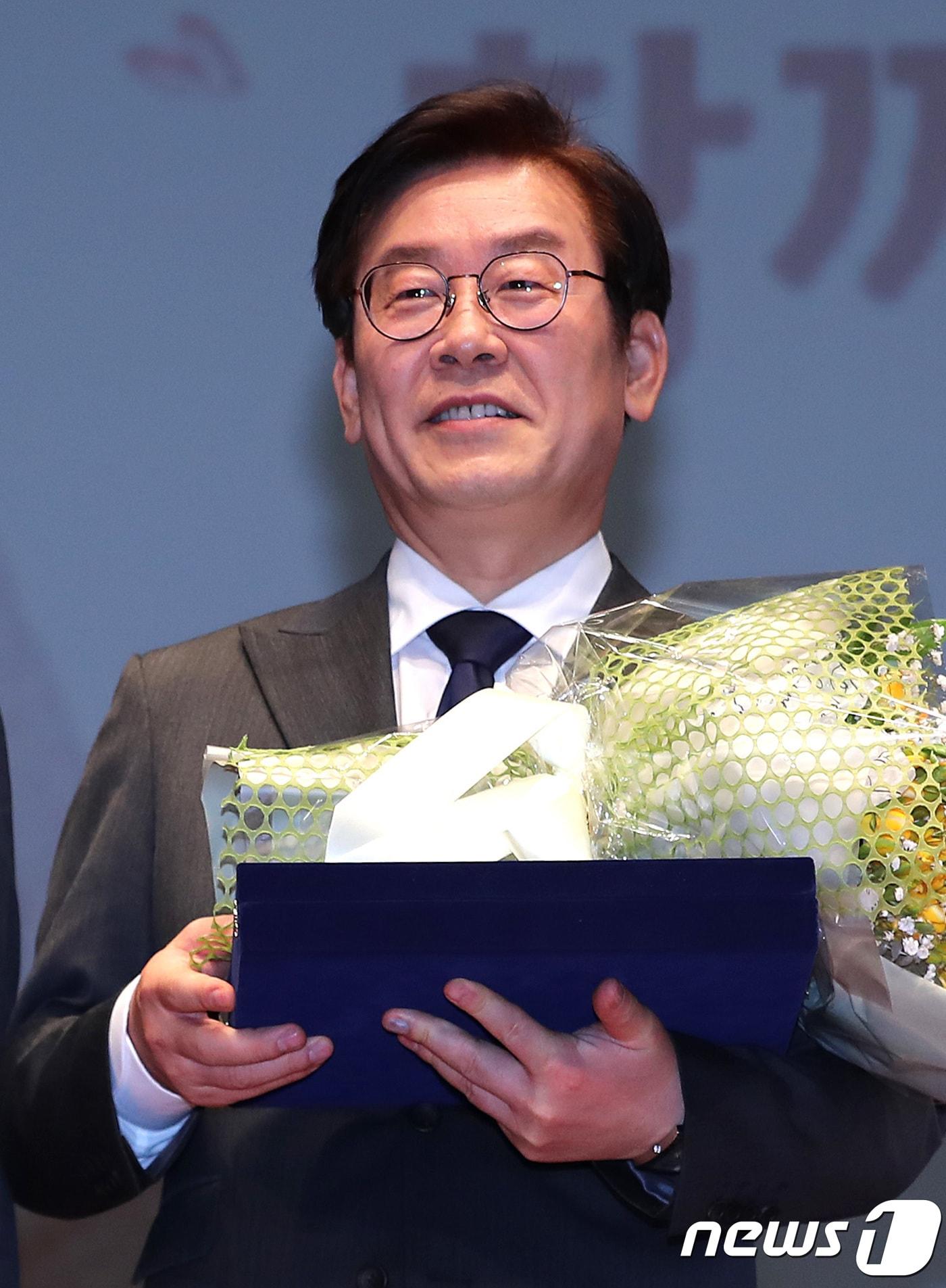 본문 이미지 - 이재명 성남시장이 14일 오후 경기도 성남시 중원구 성남시청에서 열린 민선 5,6기 성남시장 퇴임식에서 꽃다발과 공로패를 들고 있다. 2018.3.14/뉴스1 ⓒ News1 오장환 기자