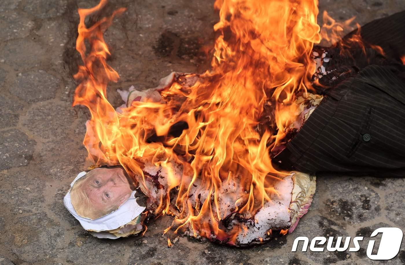 본문 이미지 - 도널드 트럼프 미국 대통령의 '예루살렘 선언'에 반대하는 팔레스타인 주민들이 그의 인형을 태우는 모습. ⓒ AFP=뉴스1